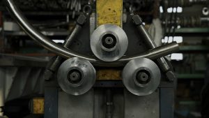 Industrial machine for cold metal pipe bending at industrial hall at manufacturing plant. Creative. Heavy industry concept.