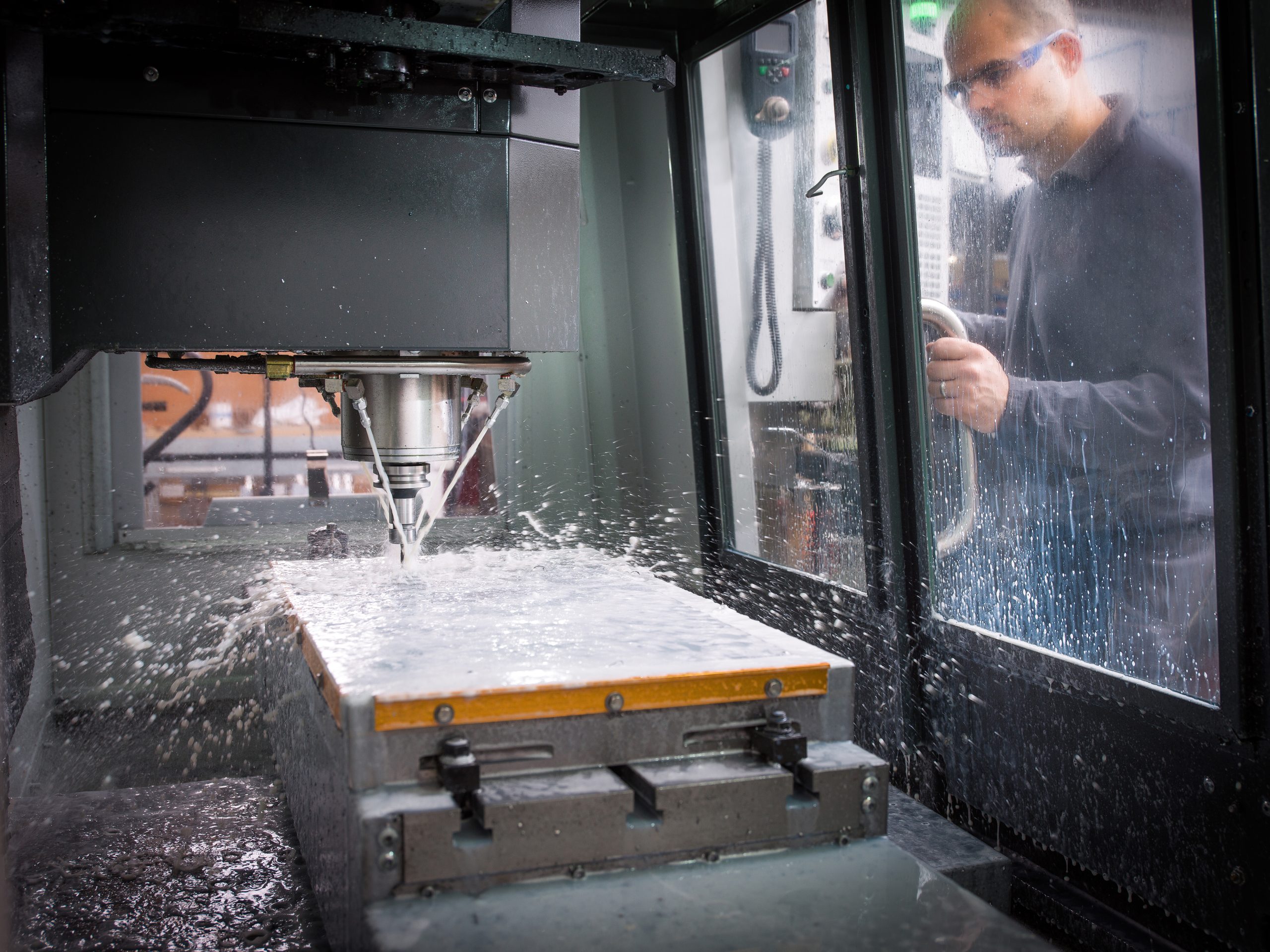 Knife factory worker monitoring machinery in workshop
