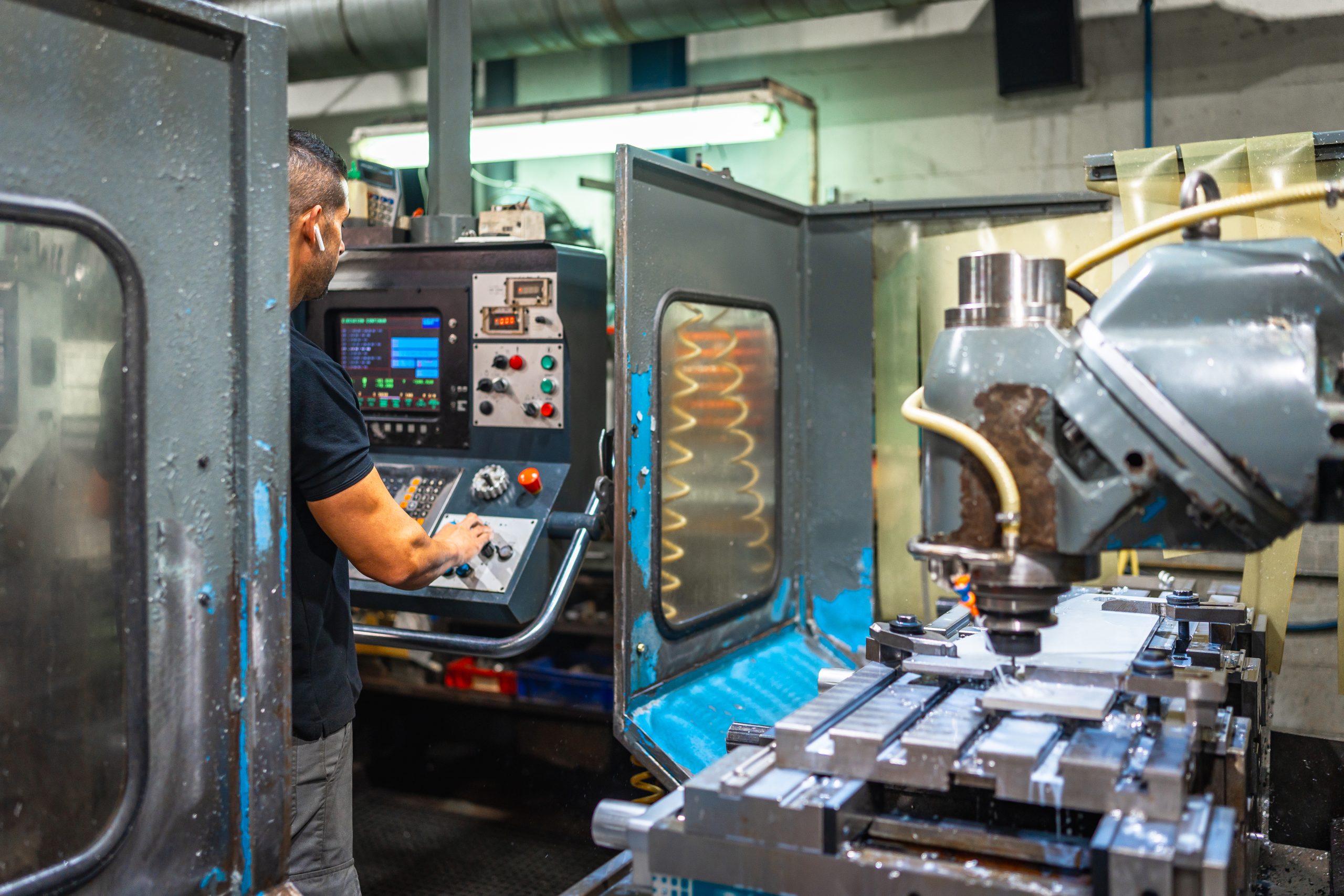 Worker using panel station of milling machine