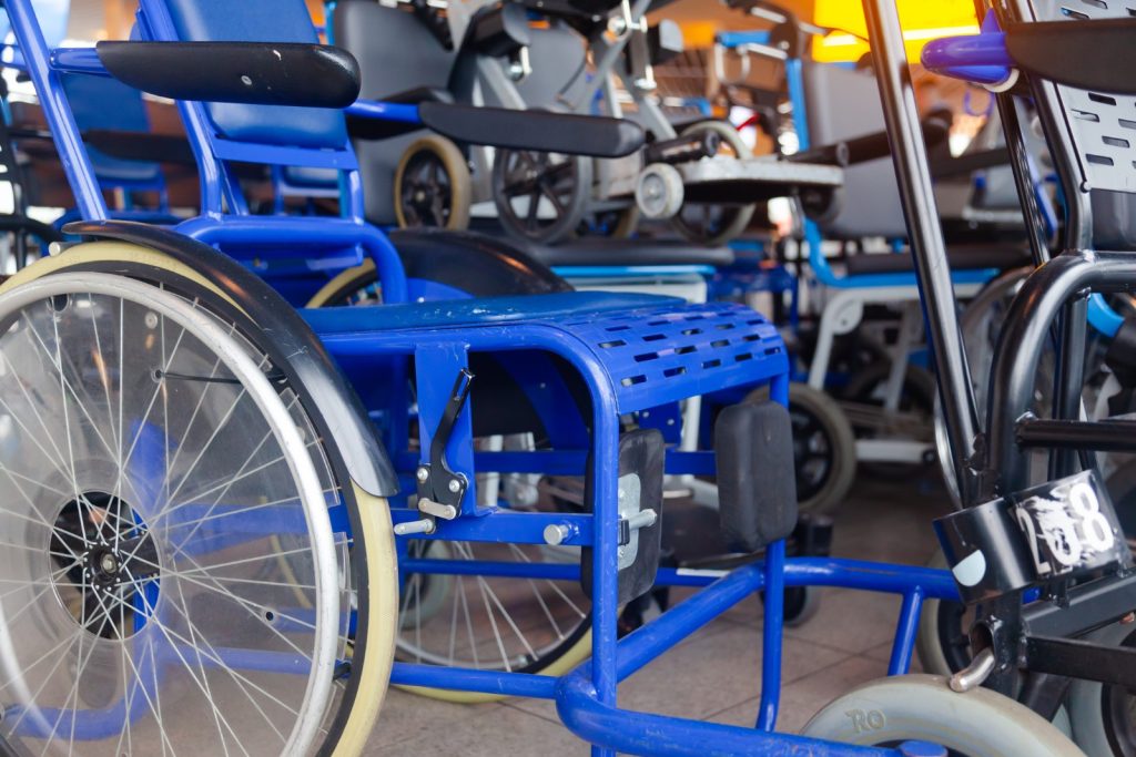 Wheelchairs stand next to each other in the airport building.